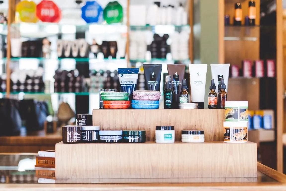 Cosmetics and skincare products displayed on wooden shelves in a retail setting.