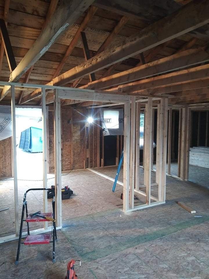A ladder is sitting in the middle of a room under construction.