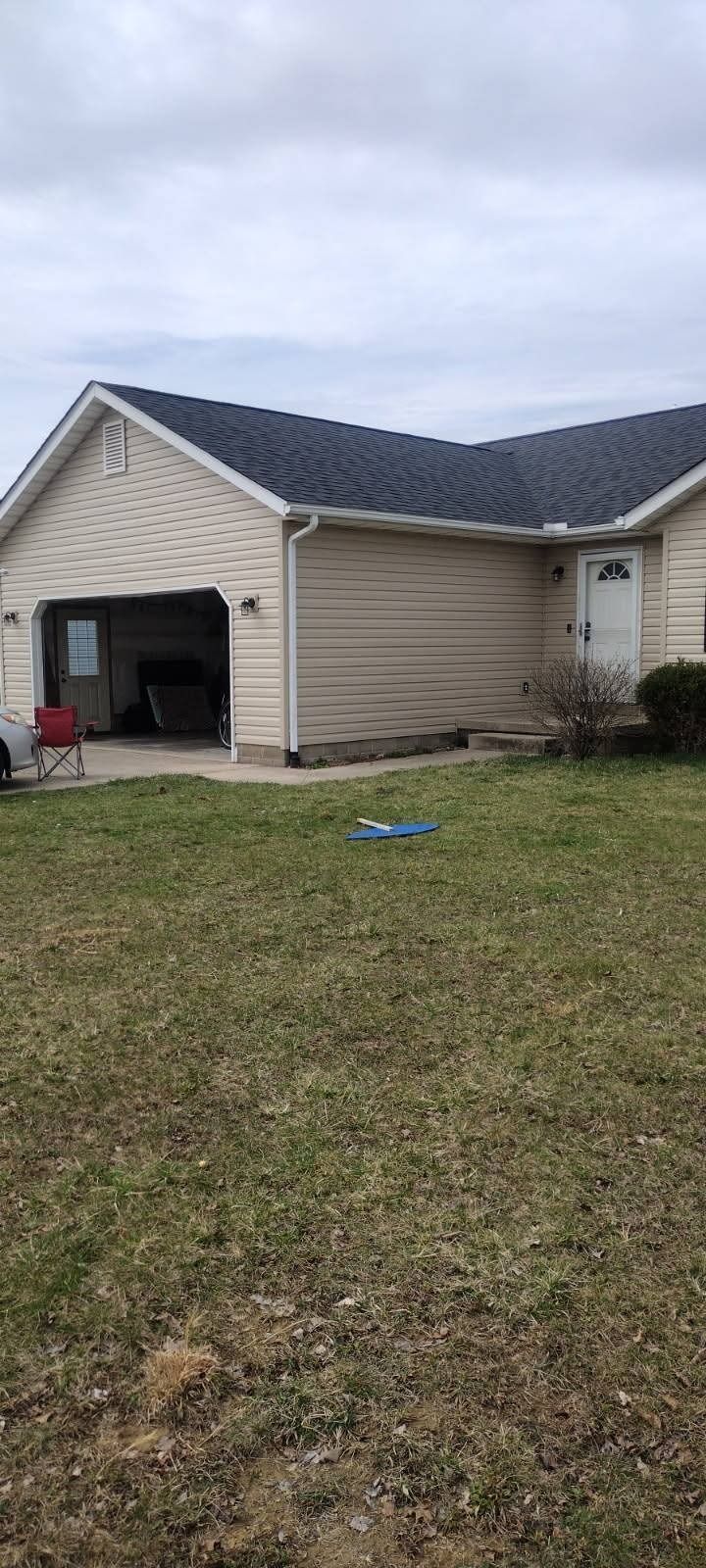 A house with a garage and a lawn in front of it.