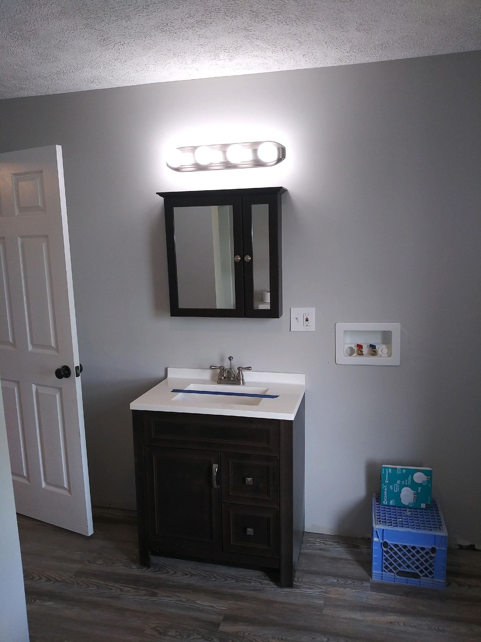 A bathroom with a sink , mirror and vanity.