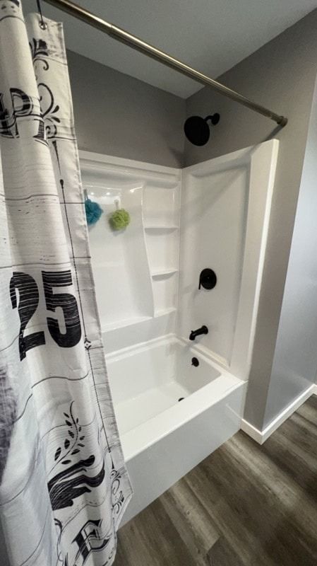 A bathroom with a bathtub and a shower curtain with the number 25 on it.