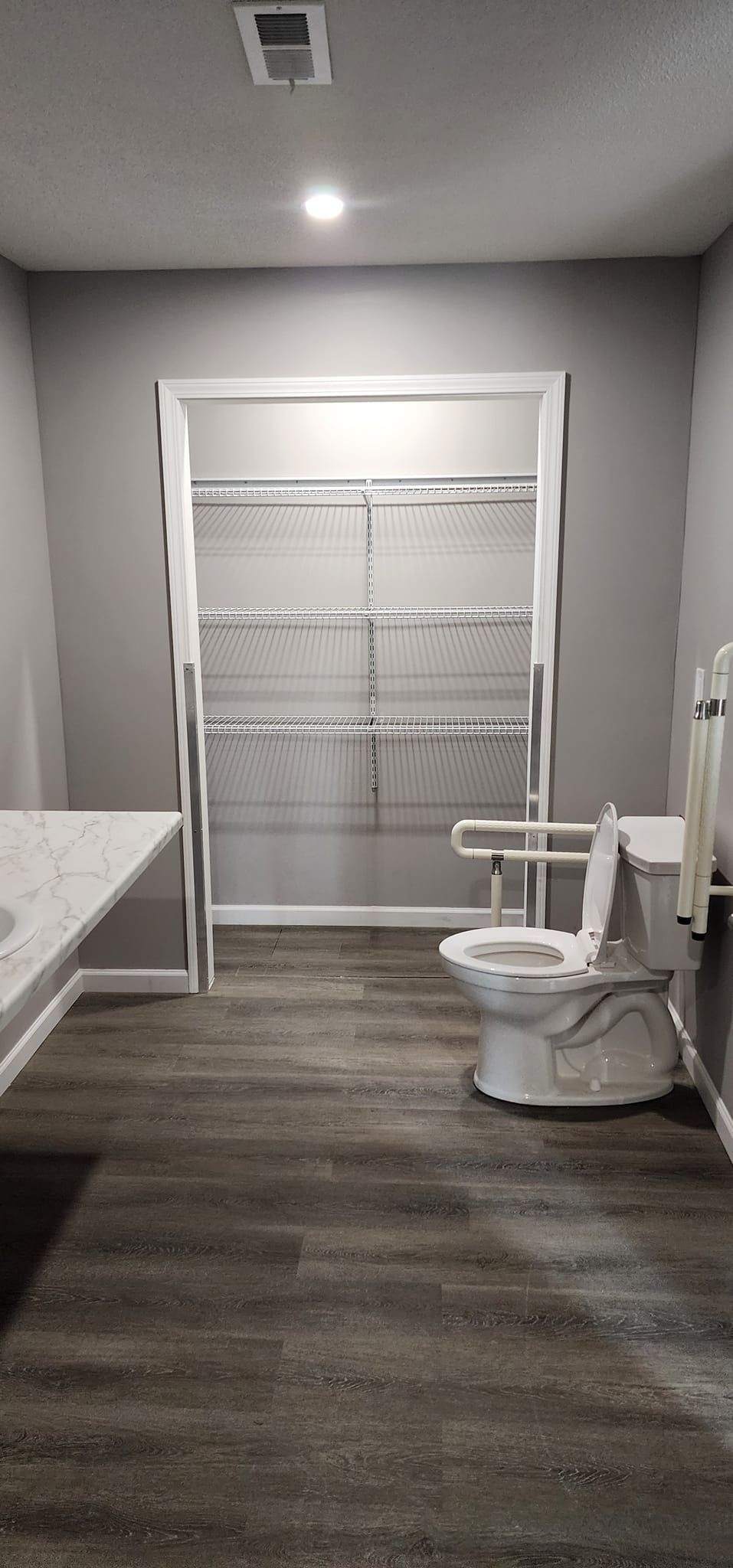 A bathroom with a toilet , sink , and door.