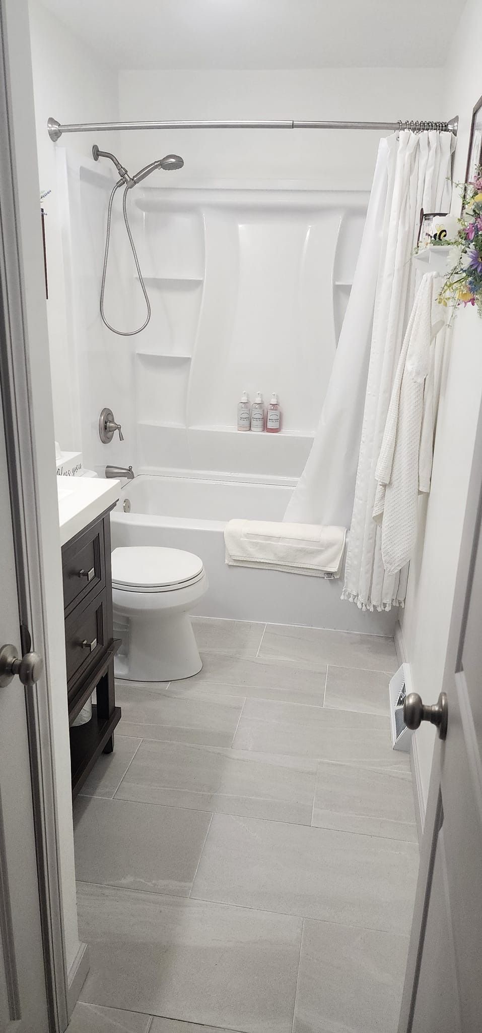 A bathroom with a tub , shower , toilet and sink.