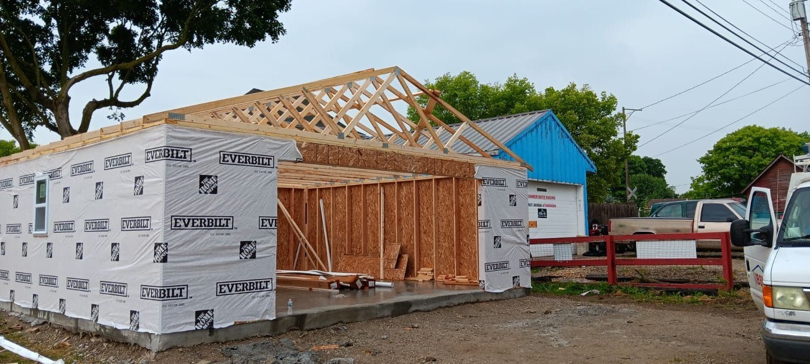 A white truck is parked in front of a building under construction.