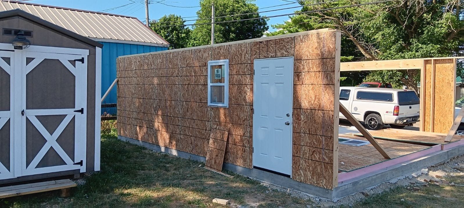 A shed is being built in the backyard of a house.