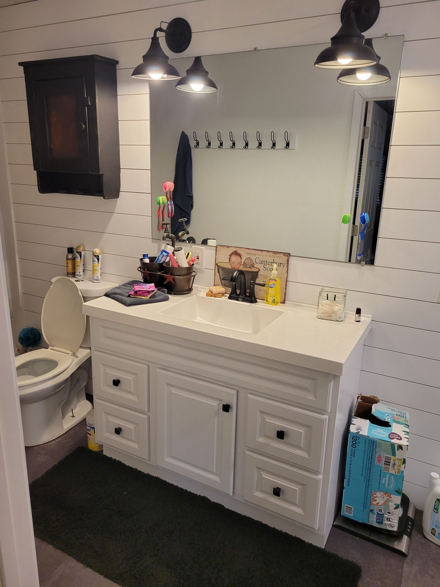 A bathroom with a sink , toilet and mirror.