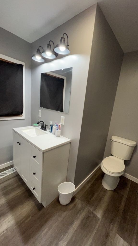 A bathroom with a sink , toilet and mirror.