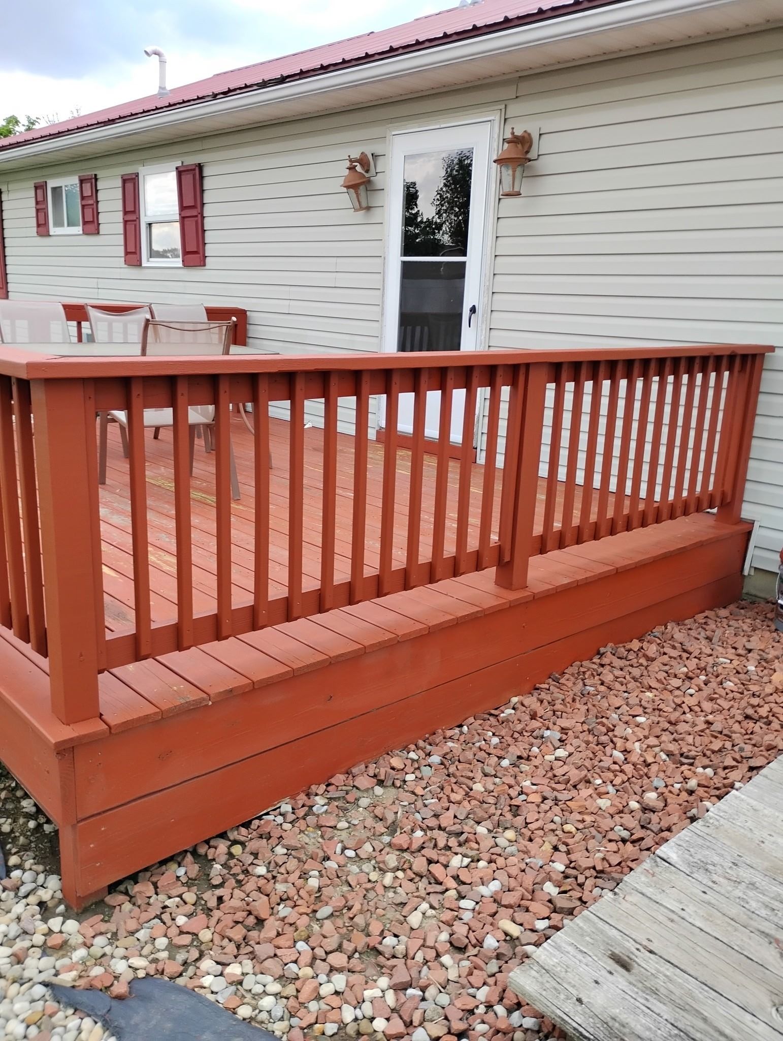 A wooden deck with a railing in front of a house.
