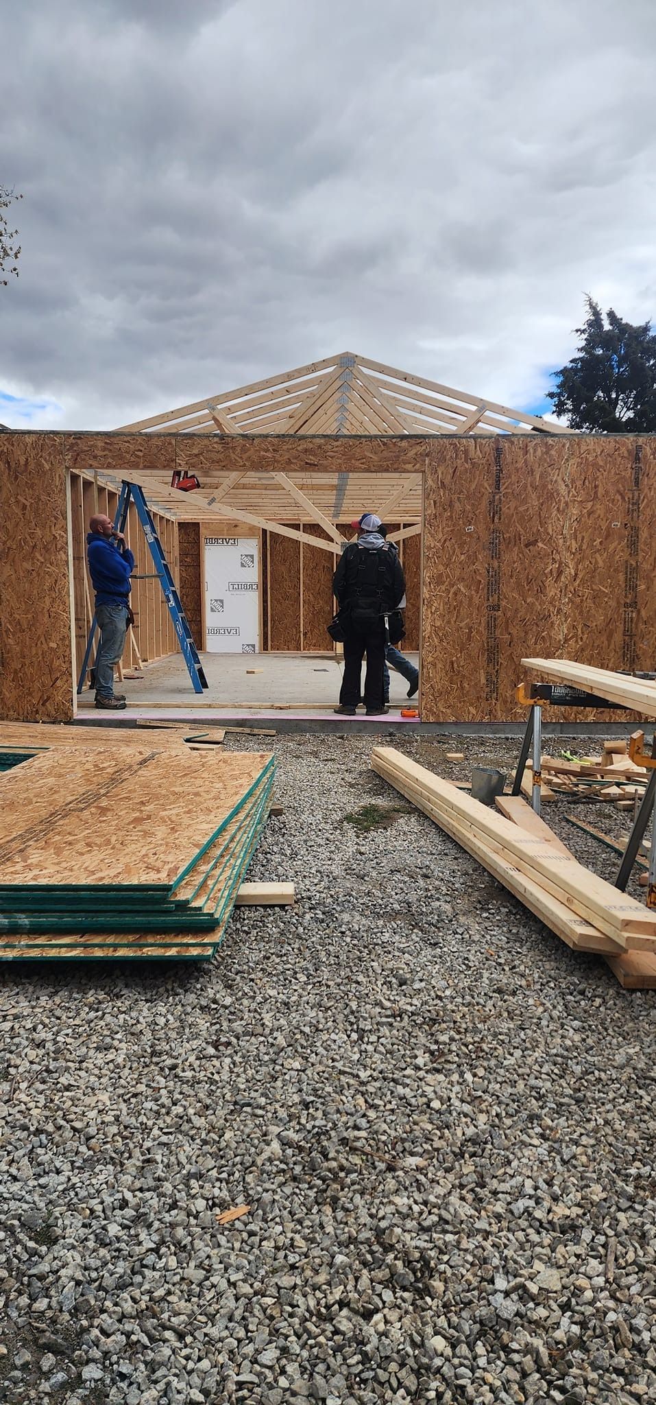 A group of people are standing in front of a house under construction.