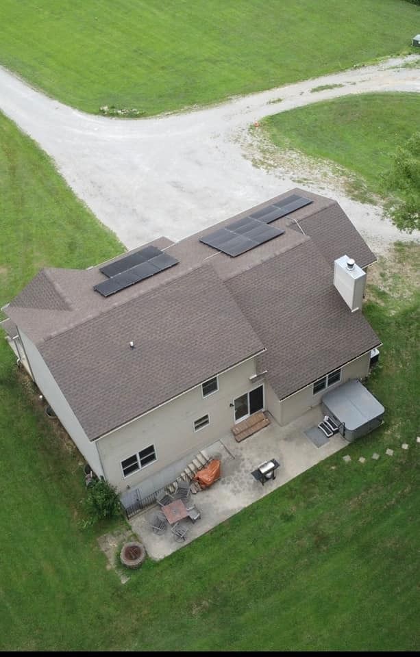An aerial view of a house with solar panels on the roof.