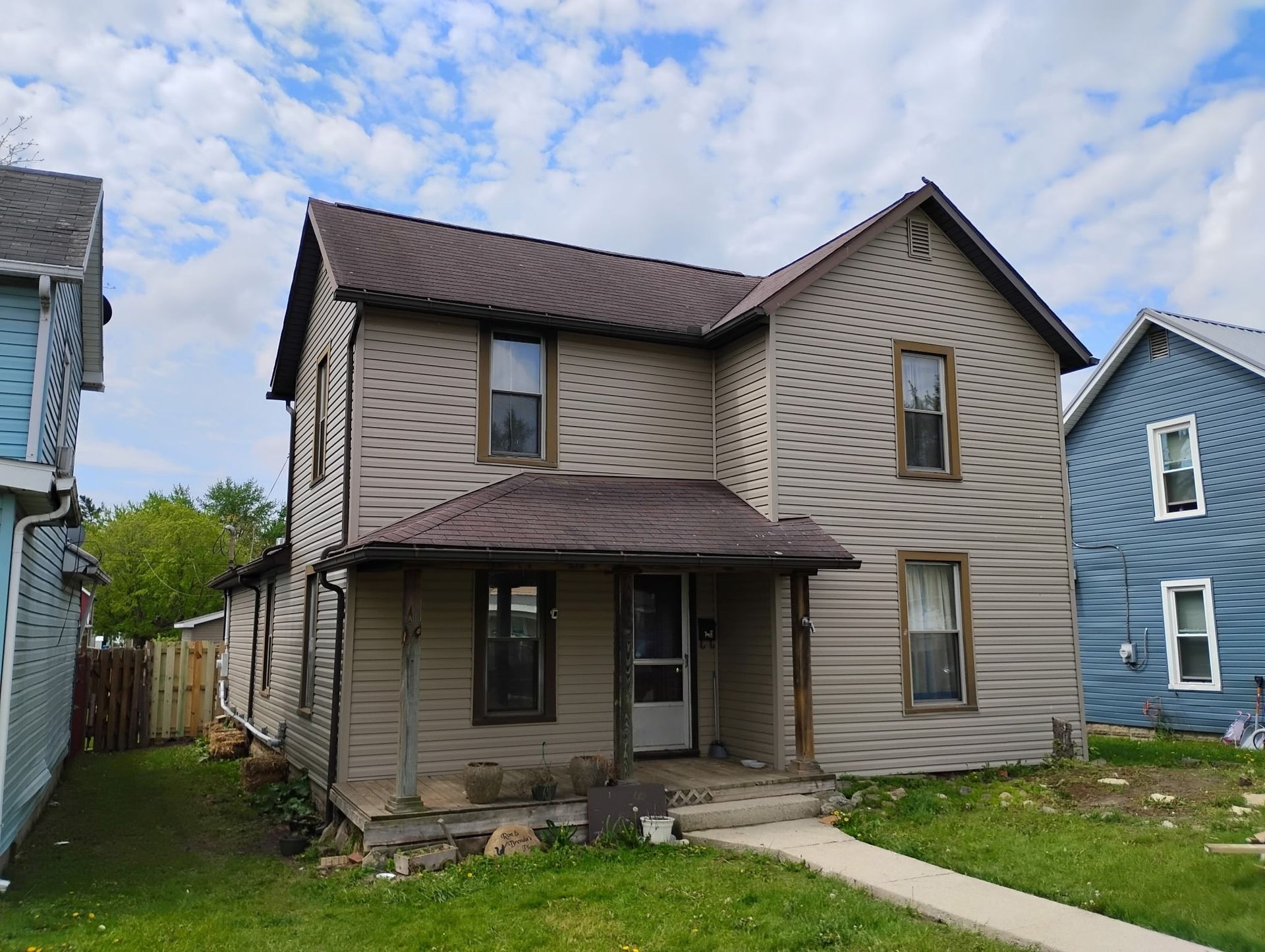 A brown house with a brown roof is next to a blue house.