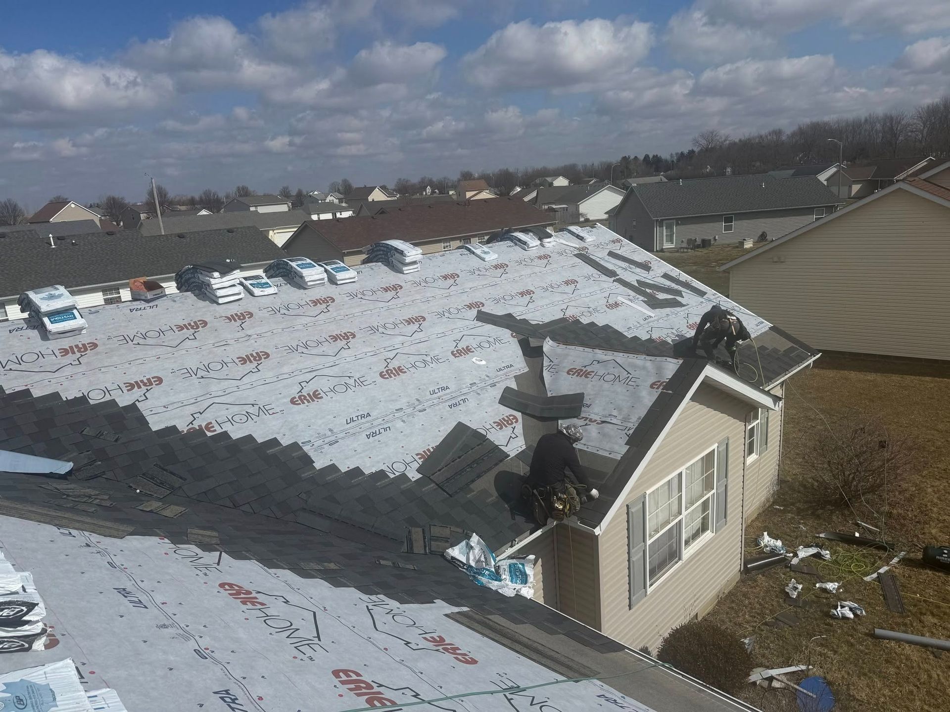 An aerial view of a roof being installed on a house