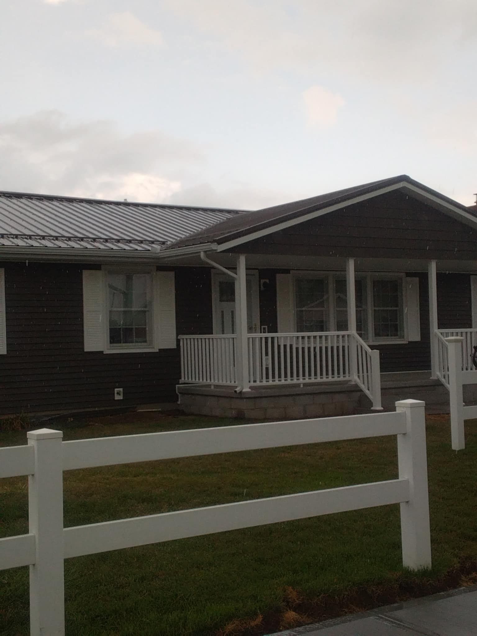 A brown house with a white fence in front of it