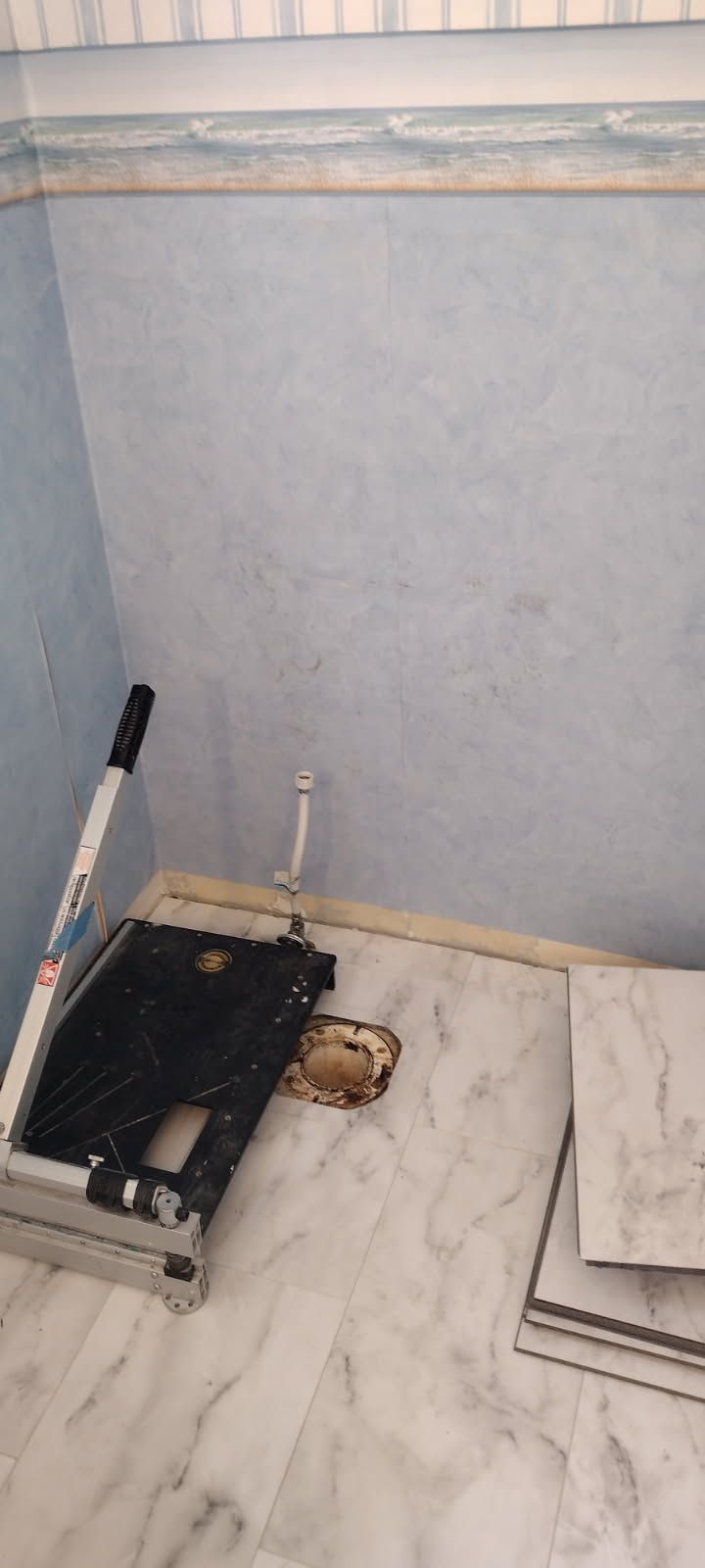 A tool is sitting on a counter next to a hole in the wall.