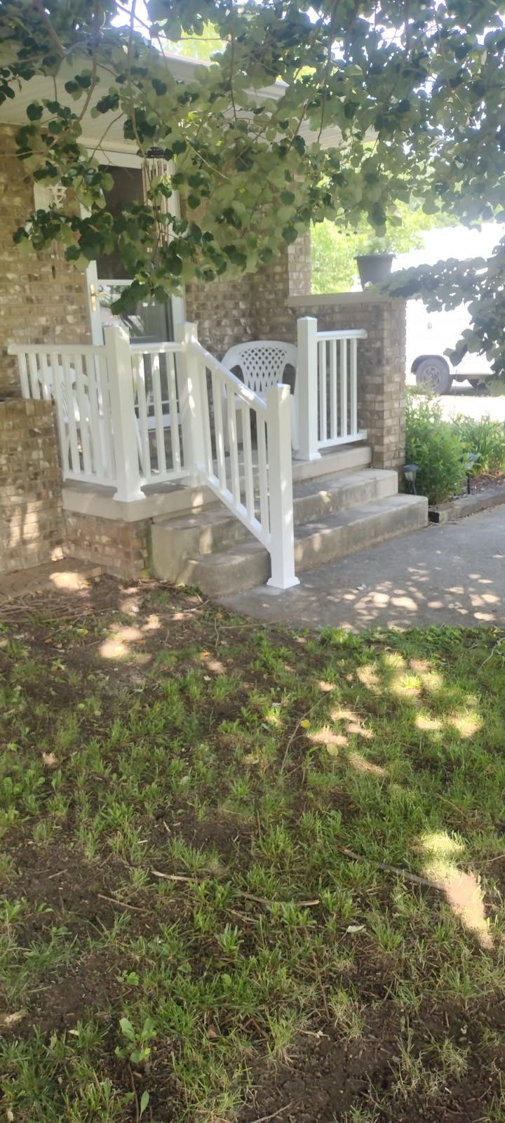 There is a white railing on the porch of a house.