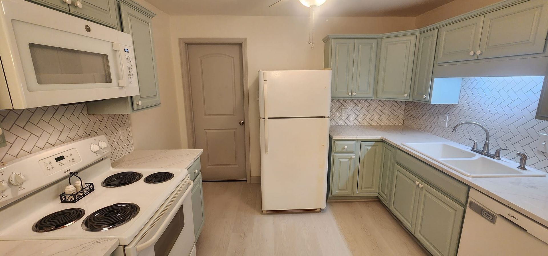 A kitchen with a refrigerator , stove , microwave , sink and dishwasher.