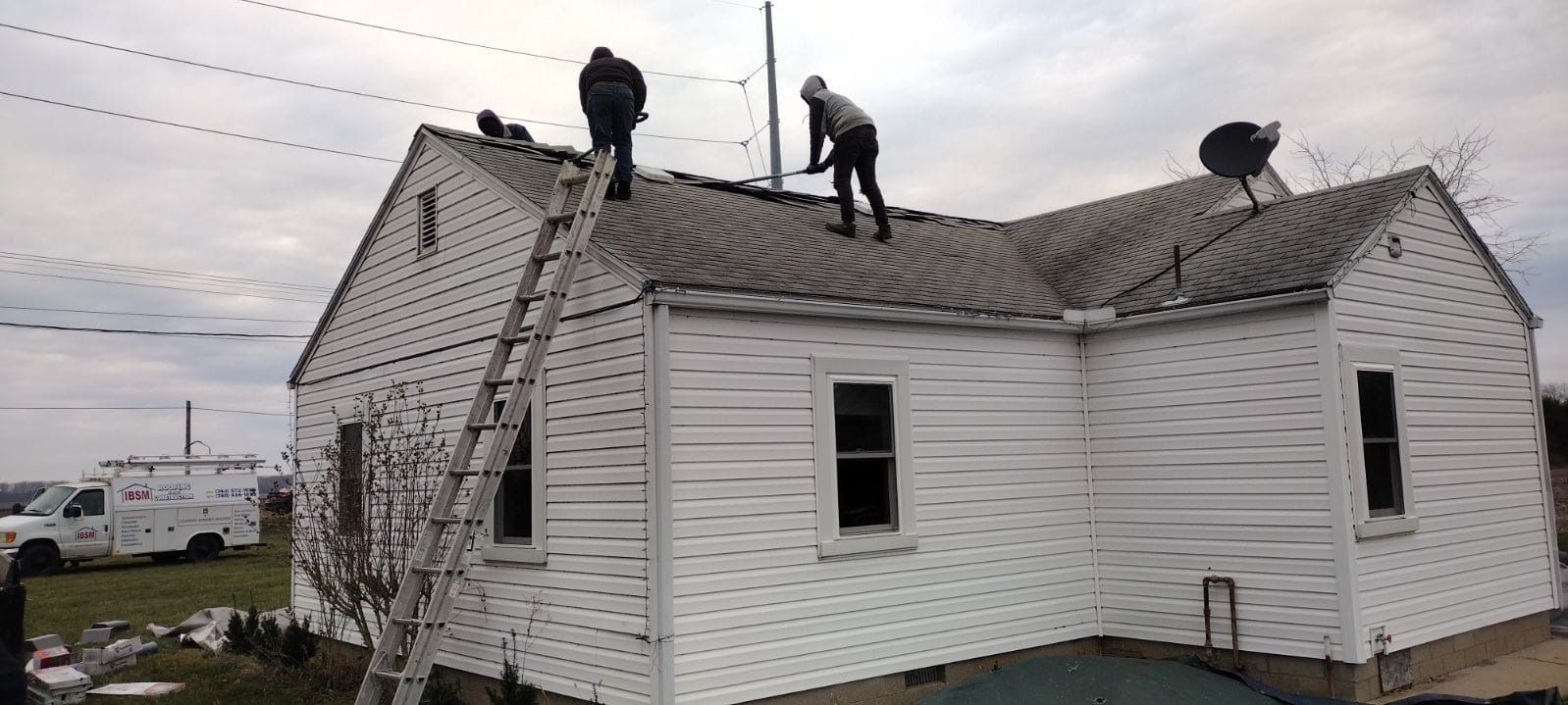 A person is standing on the roof of a house.