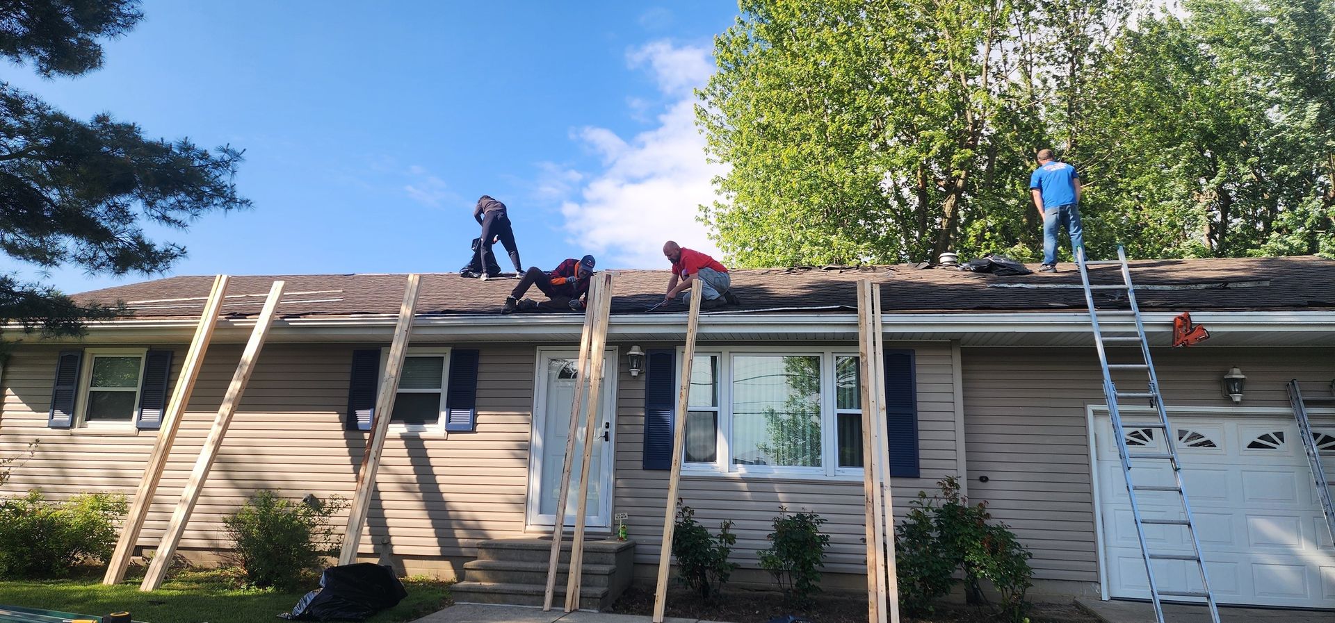 A group of people are working on the roof of a house.