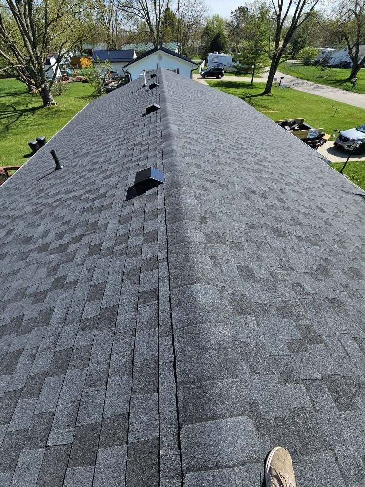 A person is standing on the roof of a house.