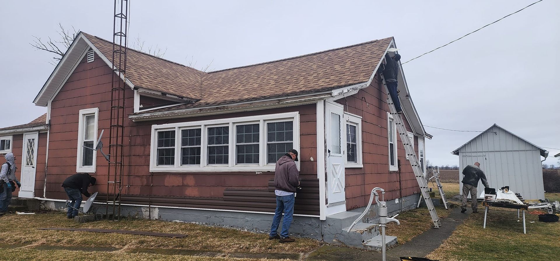 A group of people are working on a brick house.