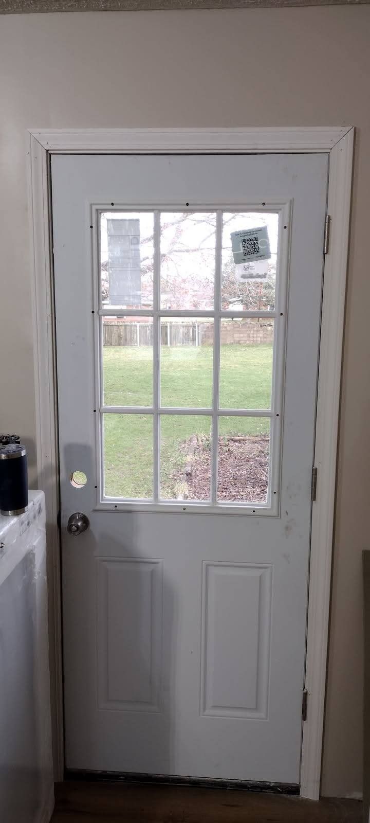 A white door with a window in a laundry room.