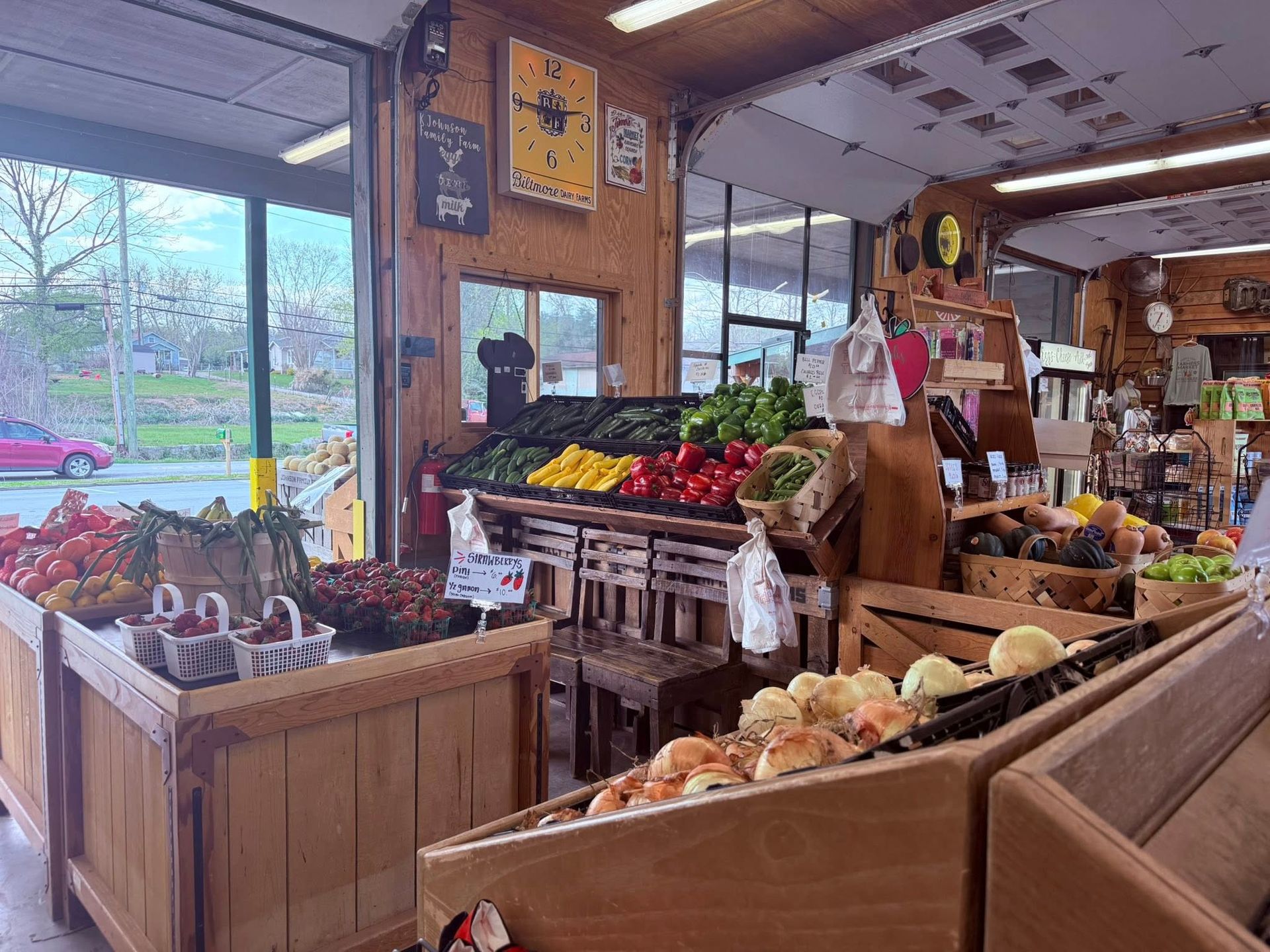 Inside a produce market with wooden bins displaying fresh fruit and vegetables for sale