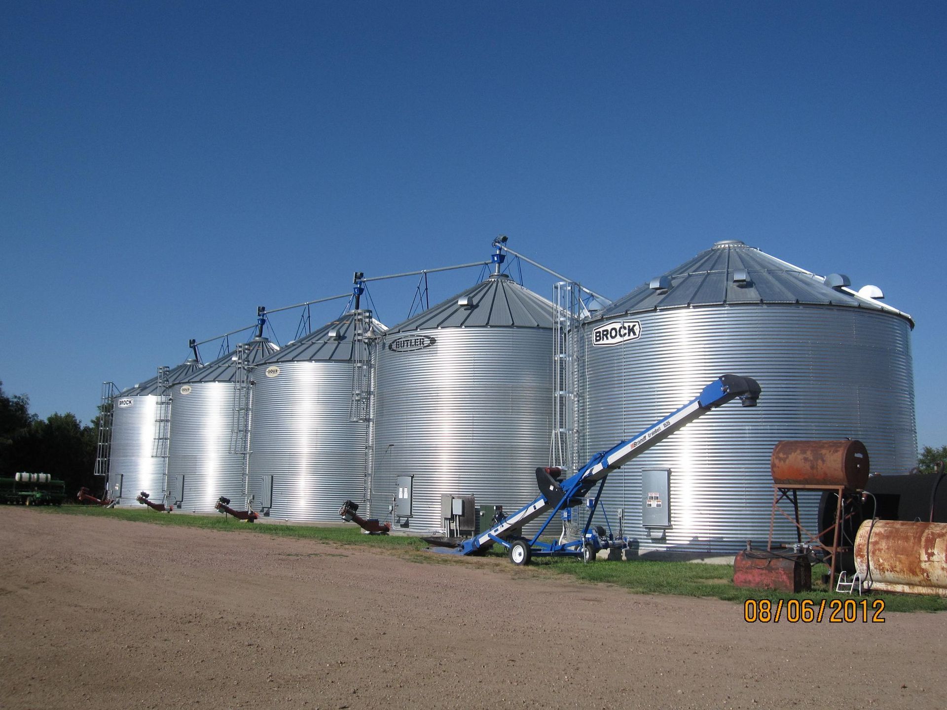 A row of silos with a conveyor belt attached to them