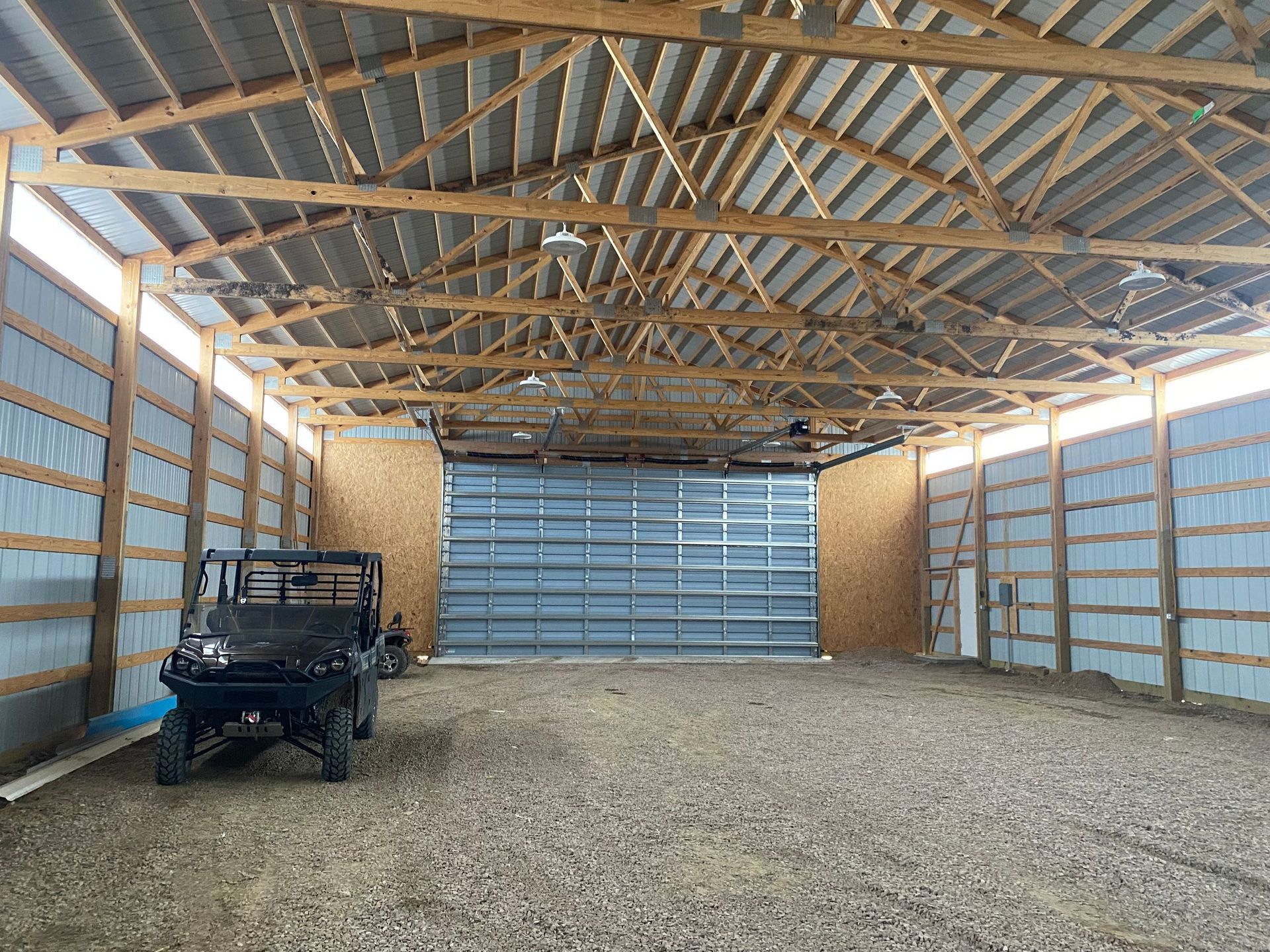 A jeep is parked inside of a garage with a large garage door.