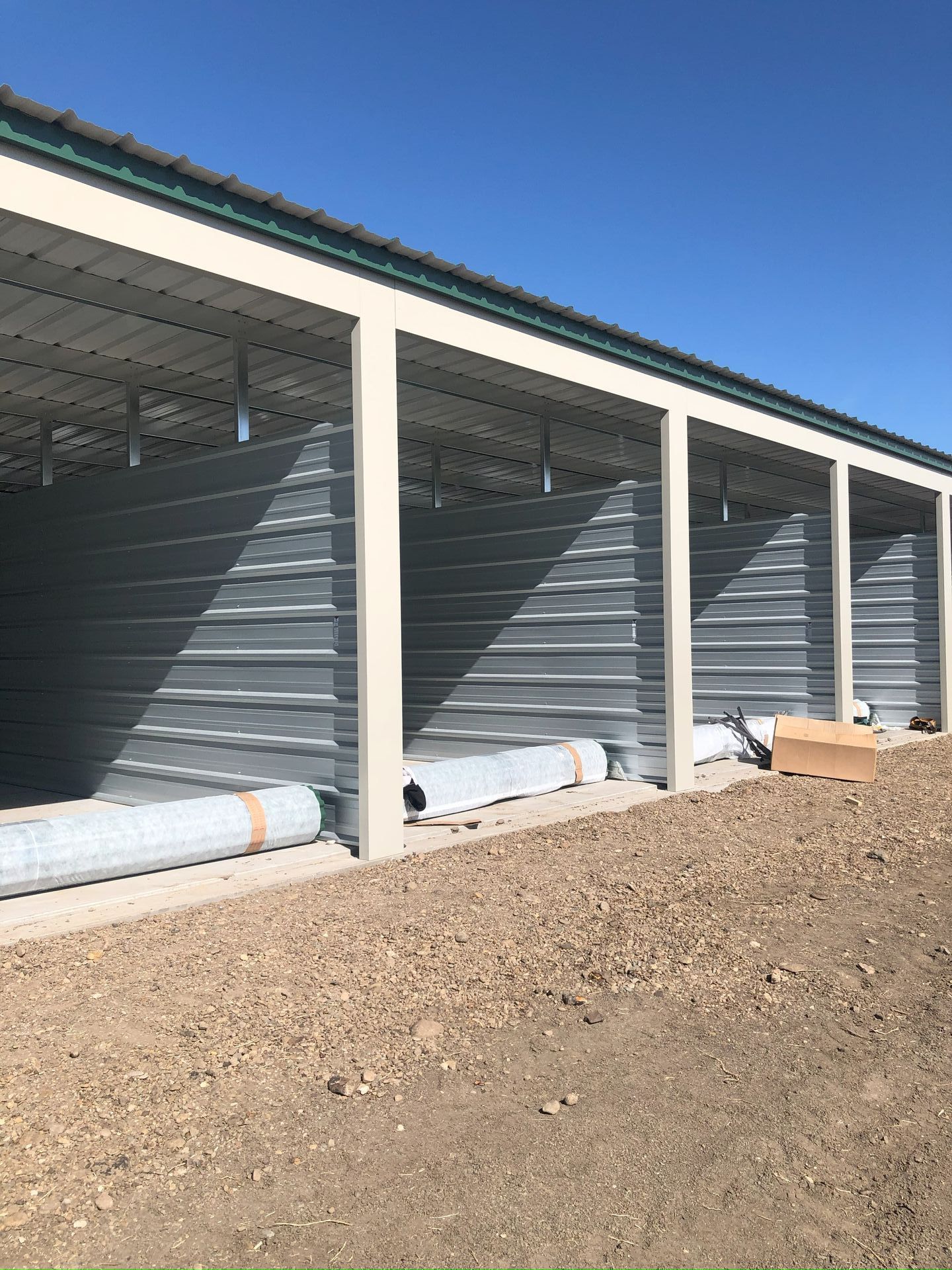 A row of storage units sitting on top of a dirt field.