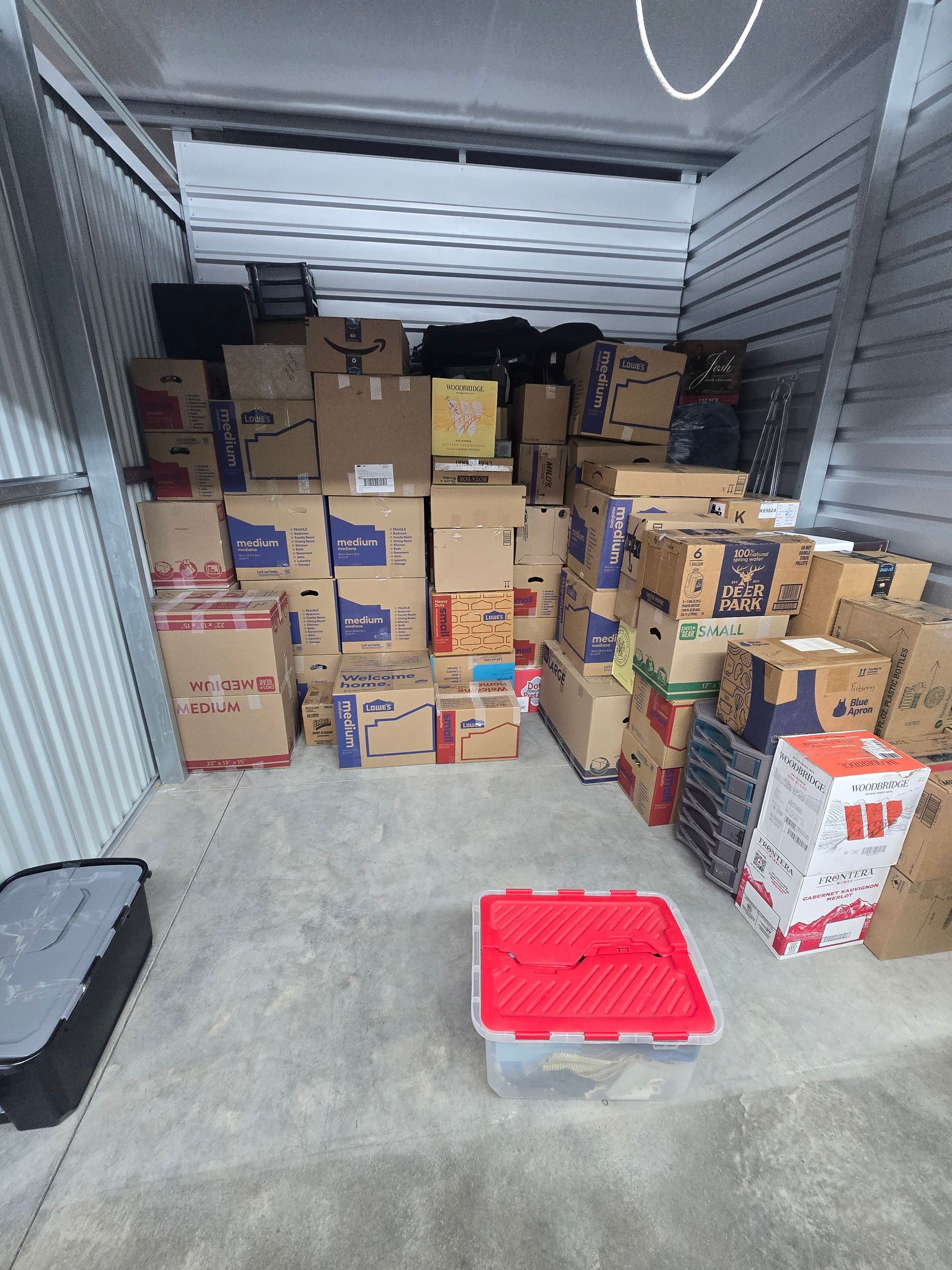 Storage truck filled with stacked cardboard boxes and a red plastic pallet on the floor