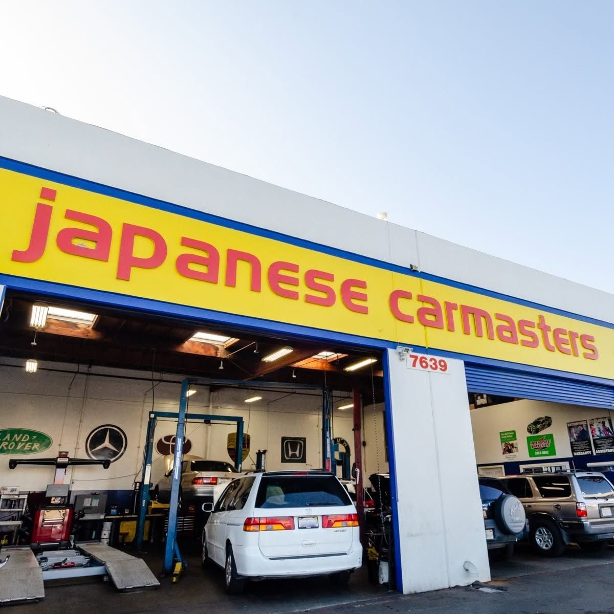 Japanese Car Masters auto shop with yellow-red sign and cars in service bays