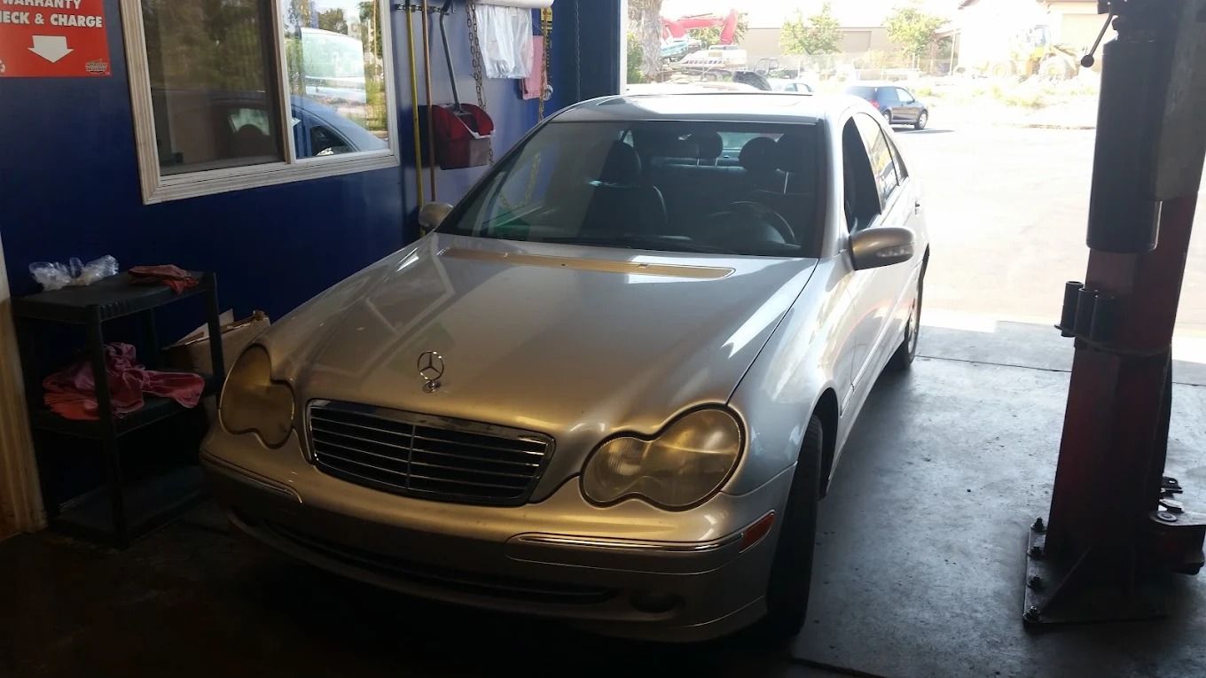 Silver sedan parked inside a garage near the entrance, with daylight outside.