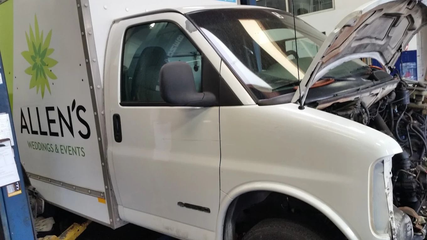 White Allen’s service truck with hood open in a garage, showing exposed engine components.