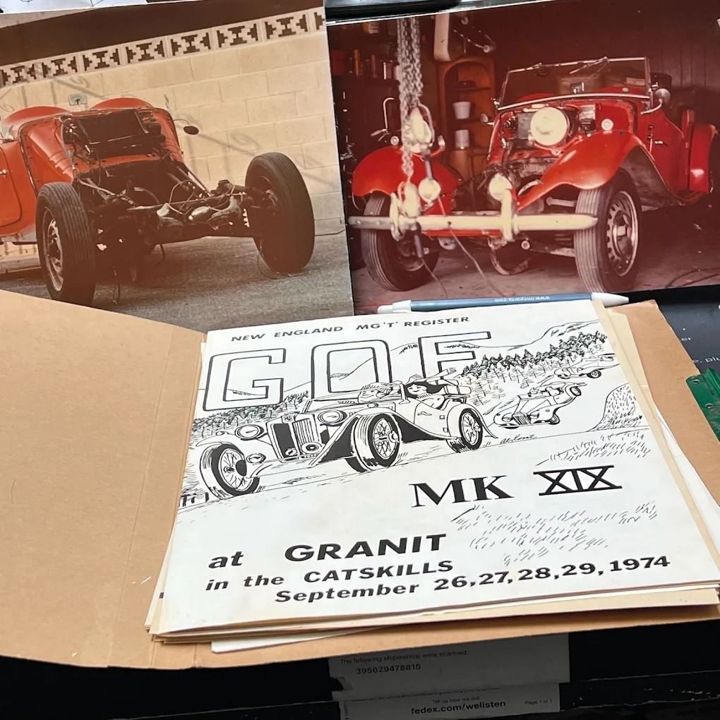 Three vintage red race car photos beside a “GOG MK XIX” Grand Prix program on a table
