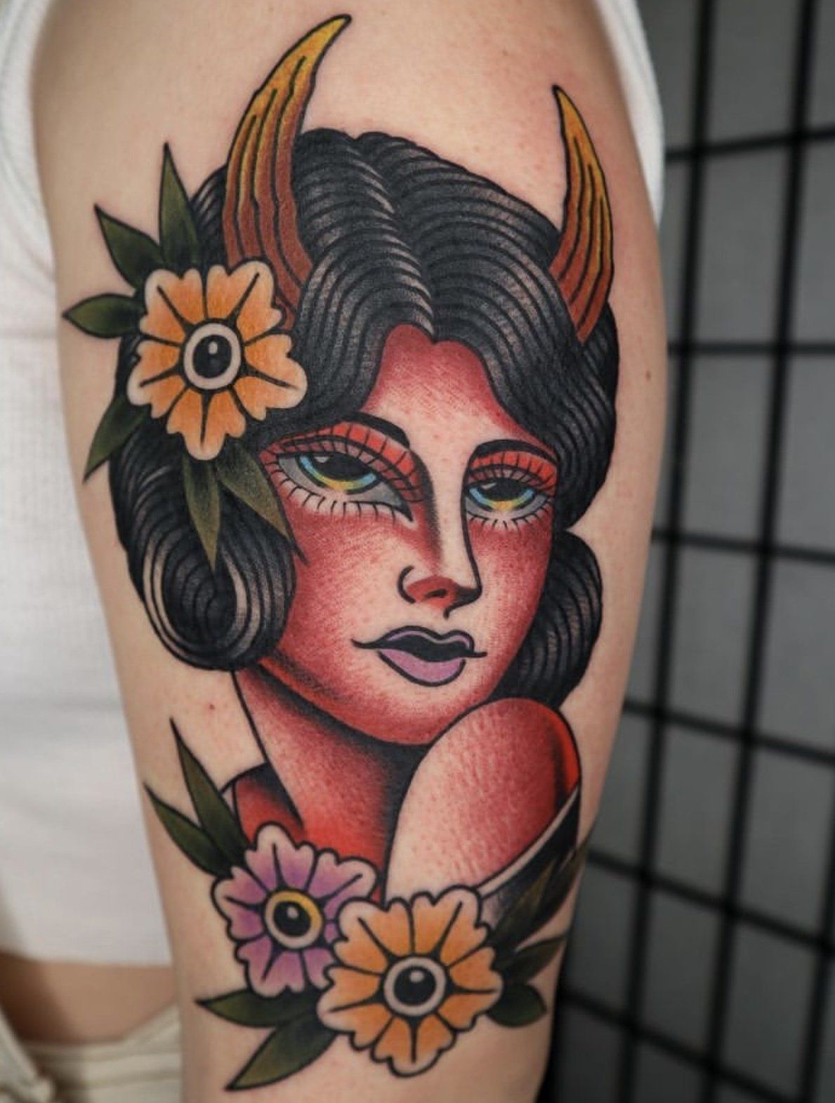 Tattoo upper arm woman with horns and flowers