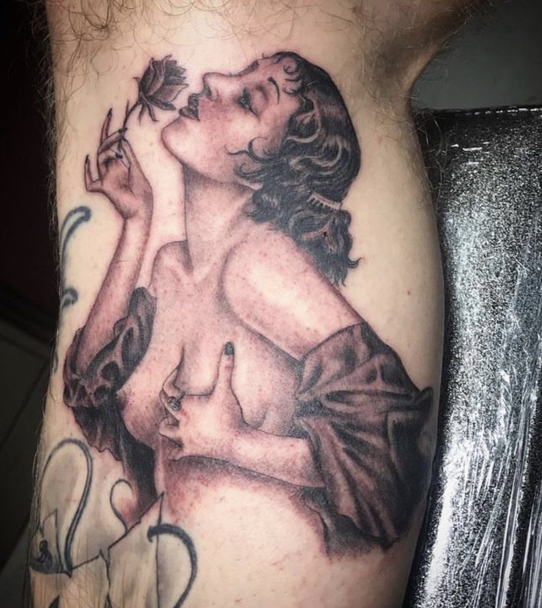 Tattoo woman holding and smelling a rose