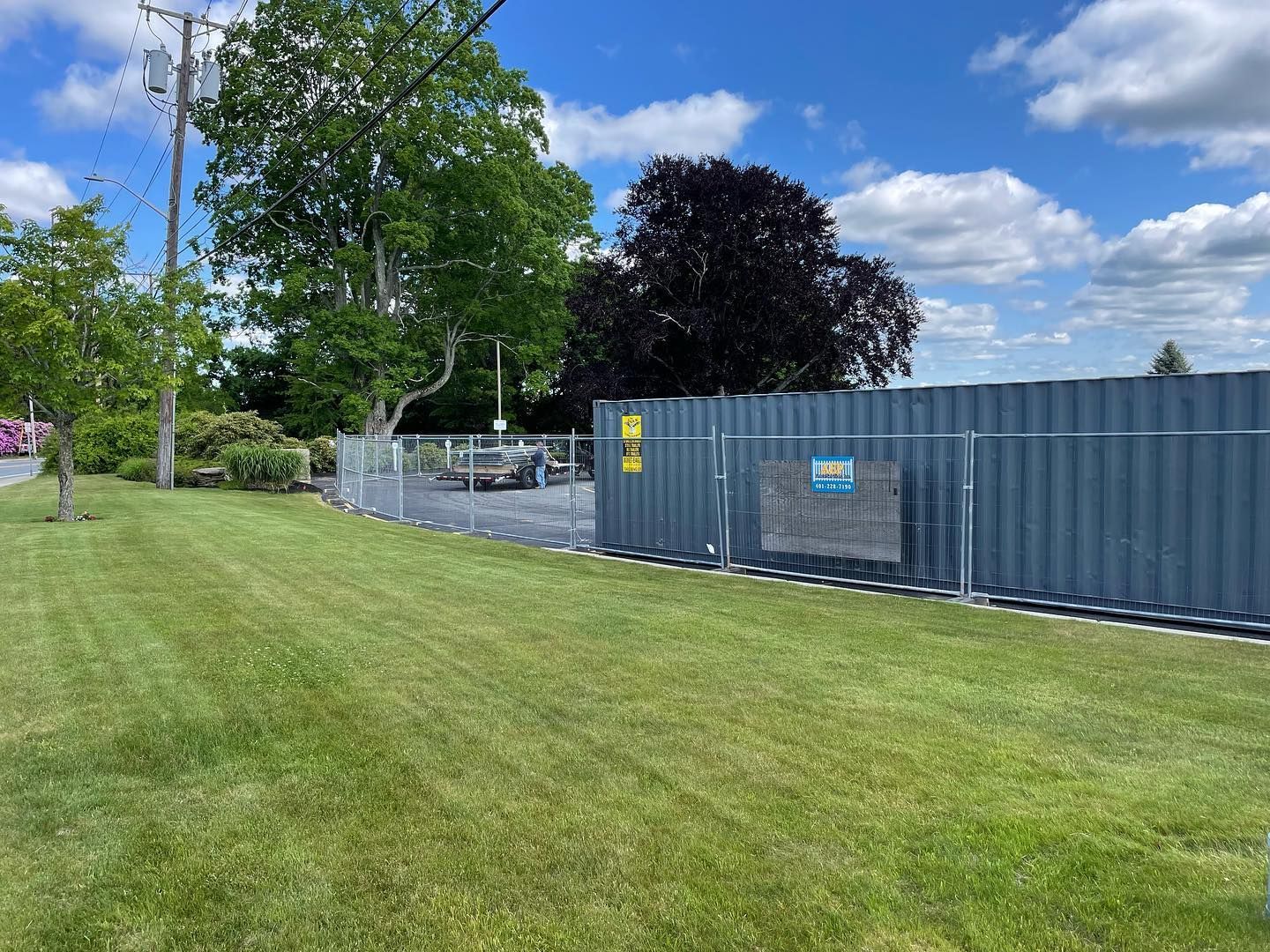 A large fence is surrounding a lush green field.