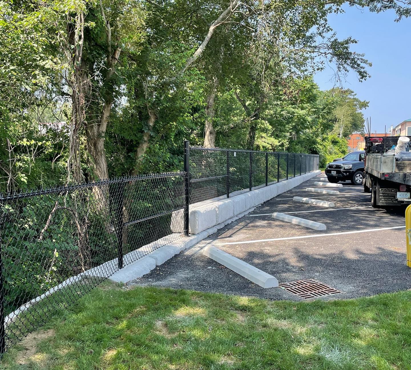 A chain link fence is surrounding a parking lot.