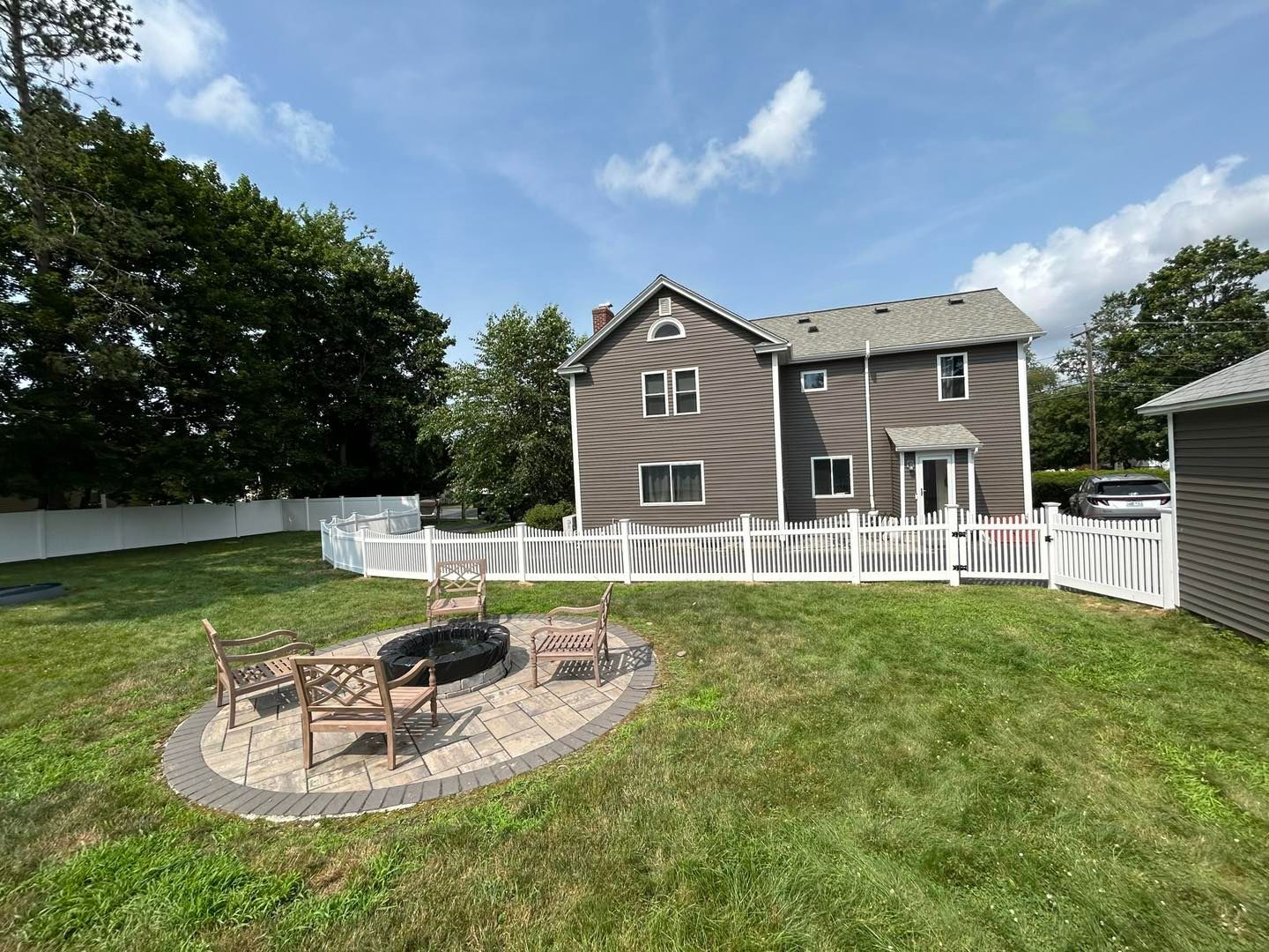 There is a fire pit in the backyard of a house.