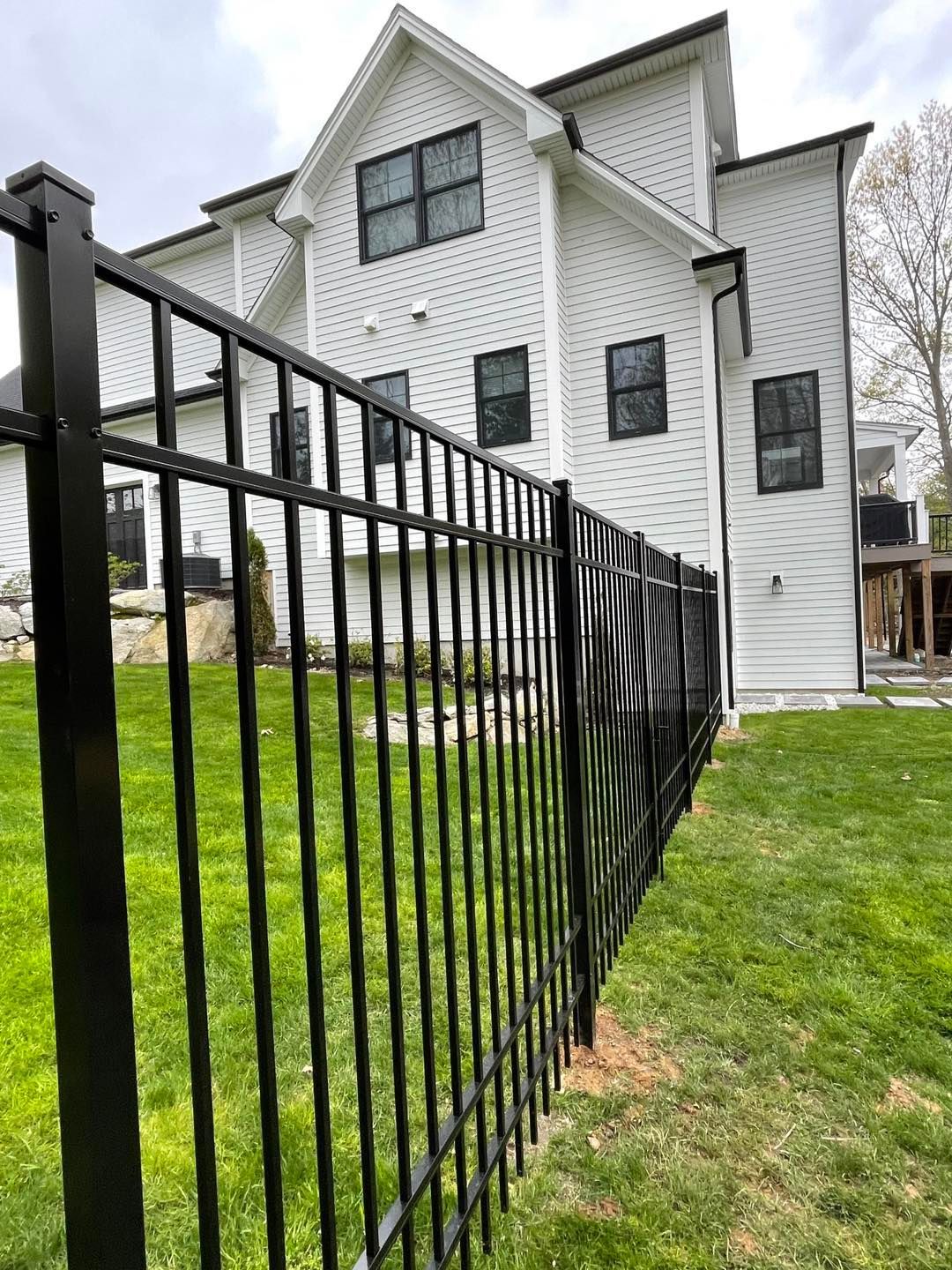 A large white house with a black fence in front of it.