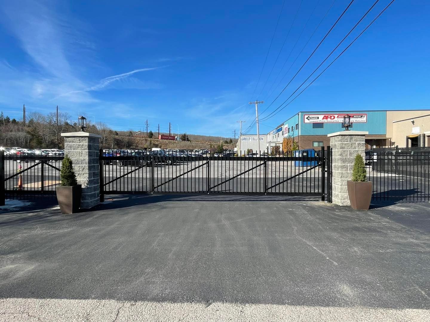 A gated entrance to a parking lot with a building in the background.