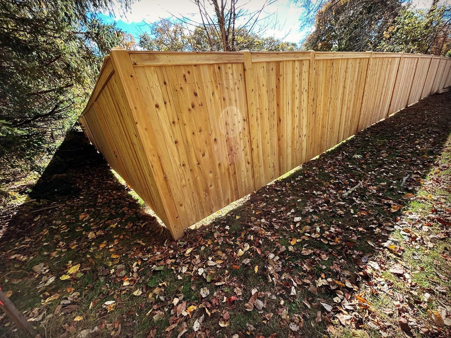 A wooden fence is sitting on top of a lush green field.