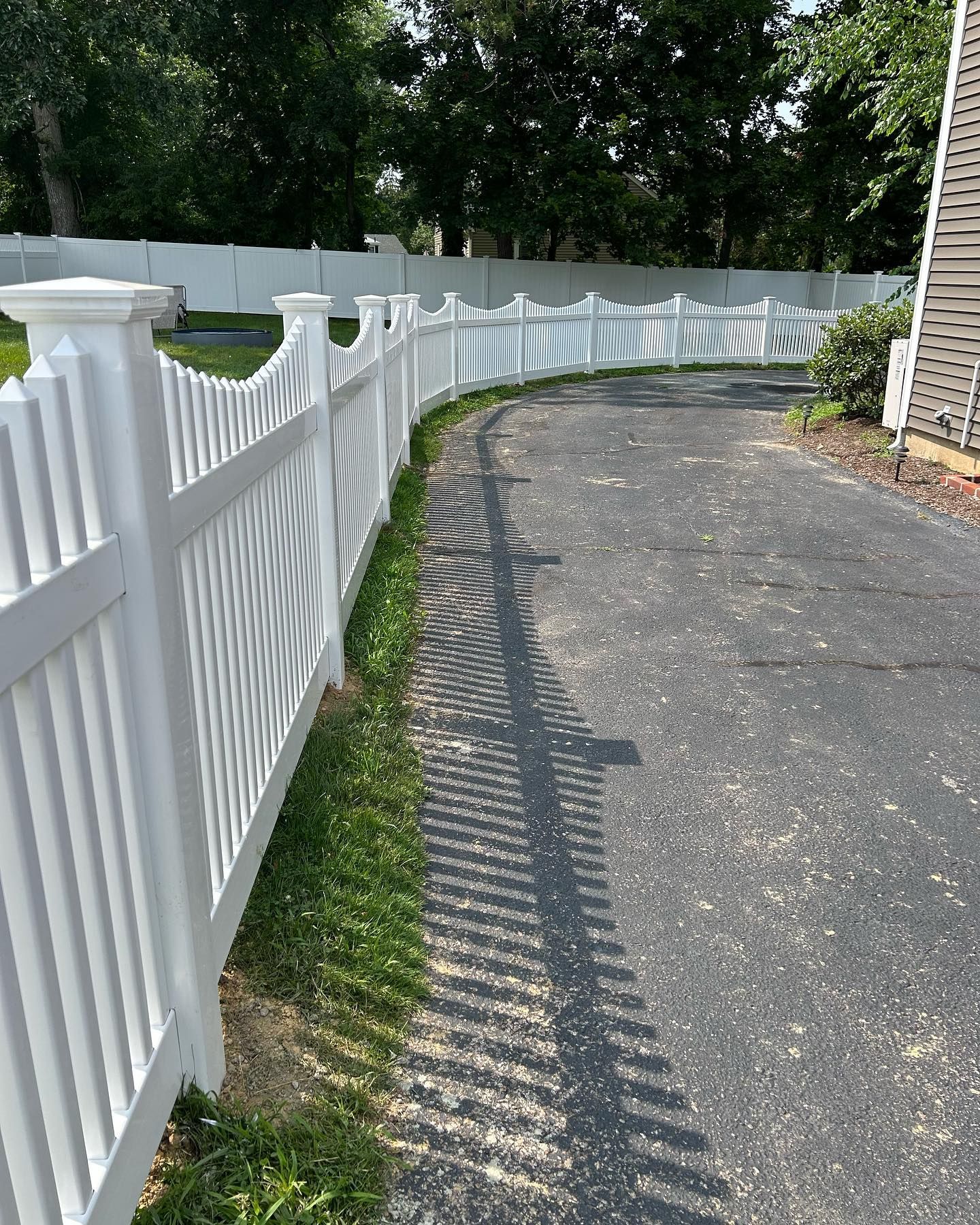 A white fence along the side of a road.