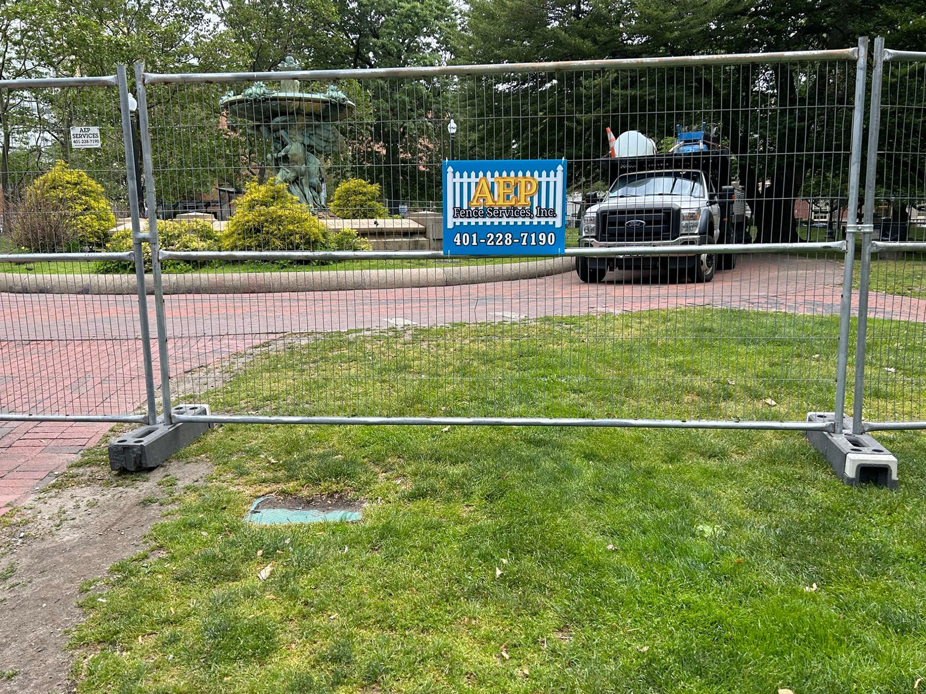 A truck is parked behind a metal fence in a park.