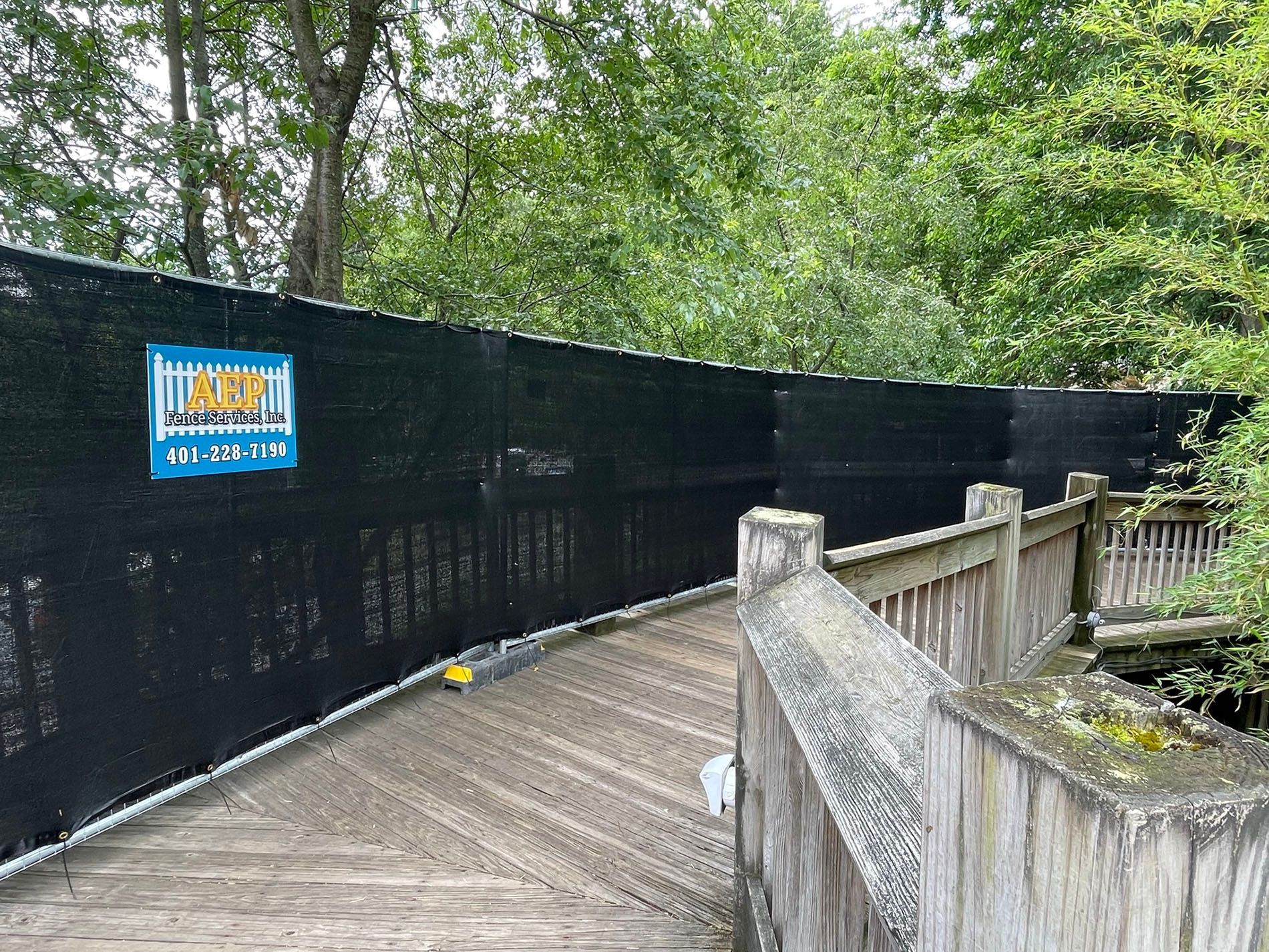 A wooden bridge with a black fence surrounding it.