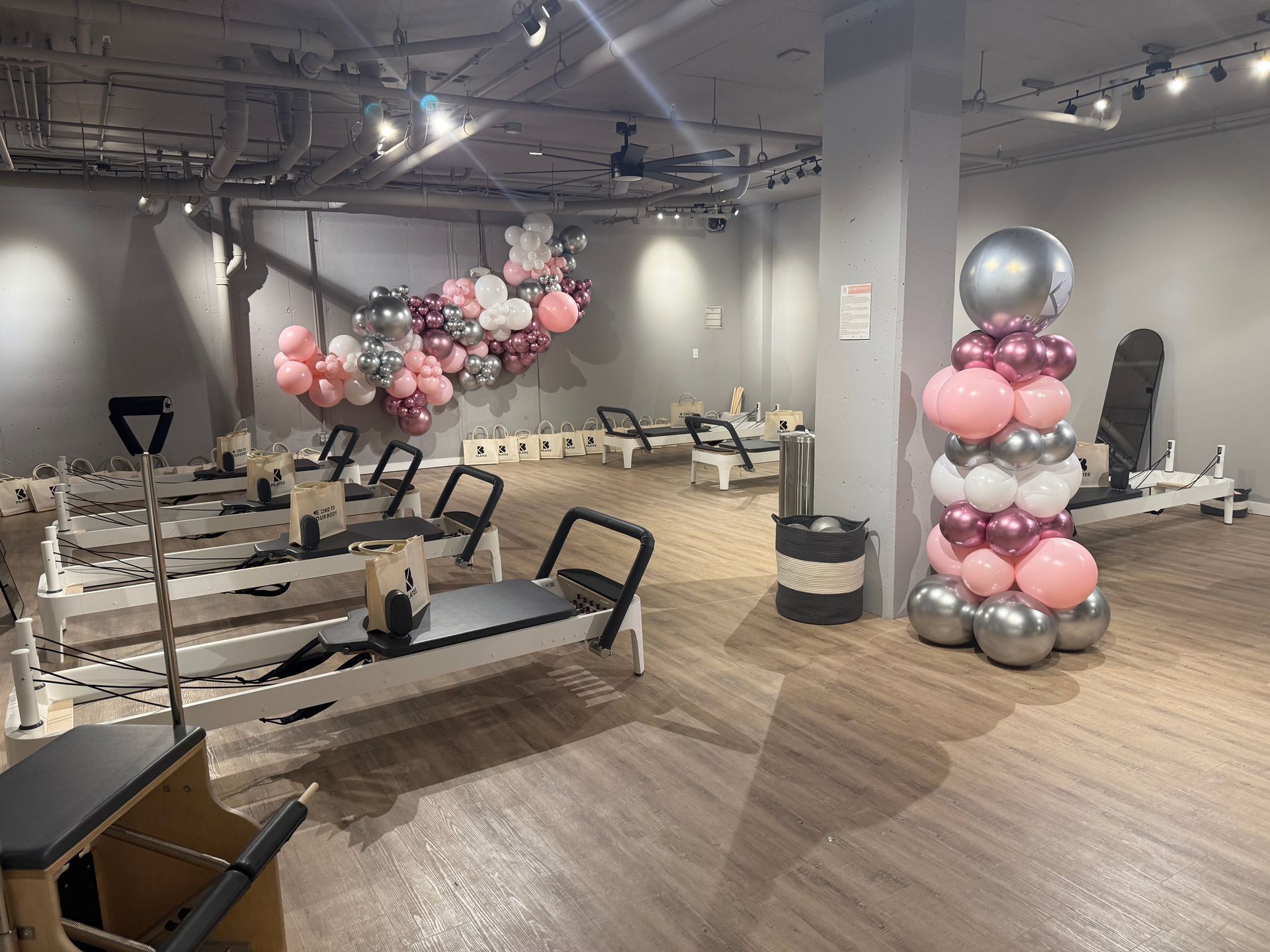 A pilates studio with balloons hanging from the ceiling.