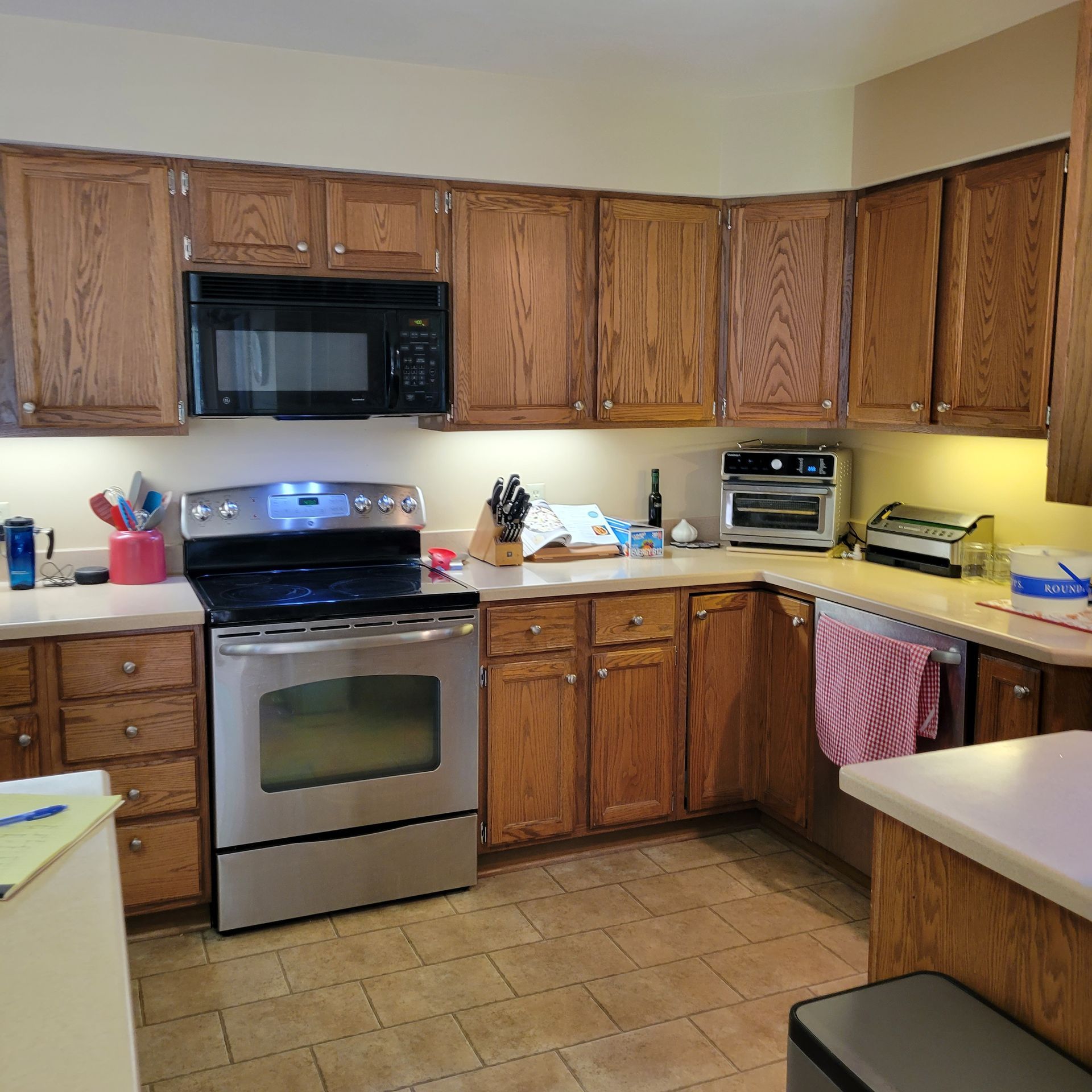 Kitchen with light-colored cabinets, stainless steel appliances, and a toaster oven on the countertop.