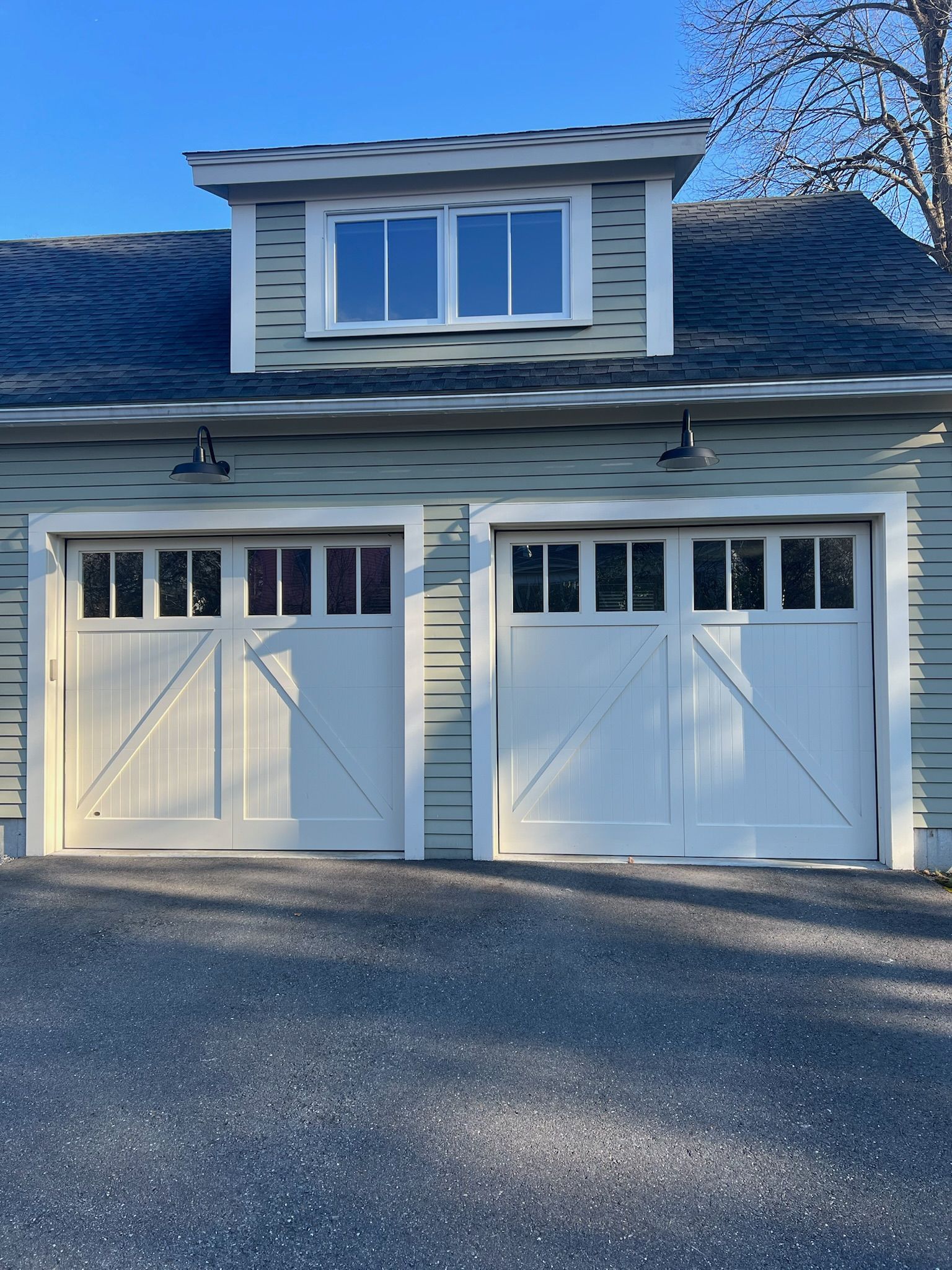 A garage with two white garage doors and a blue roof
