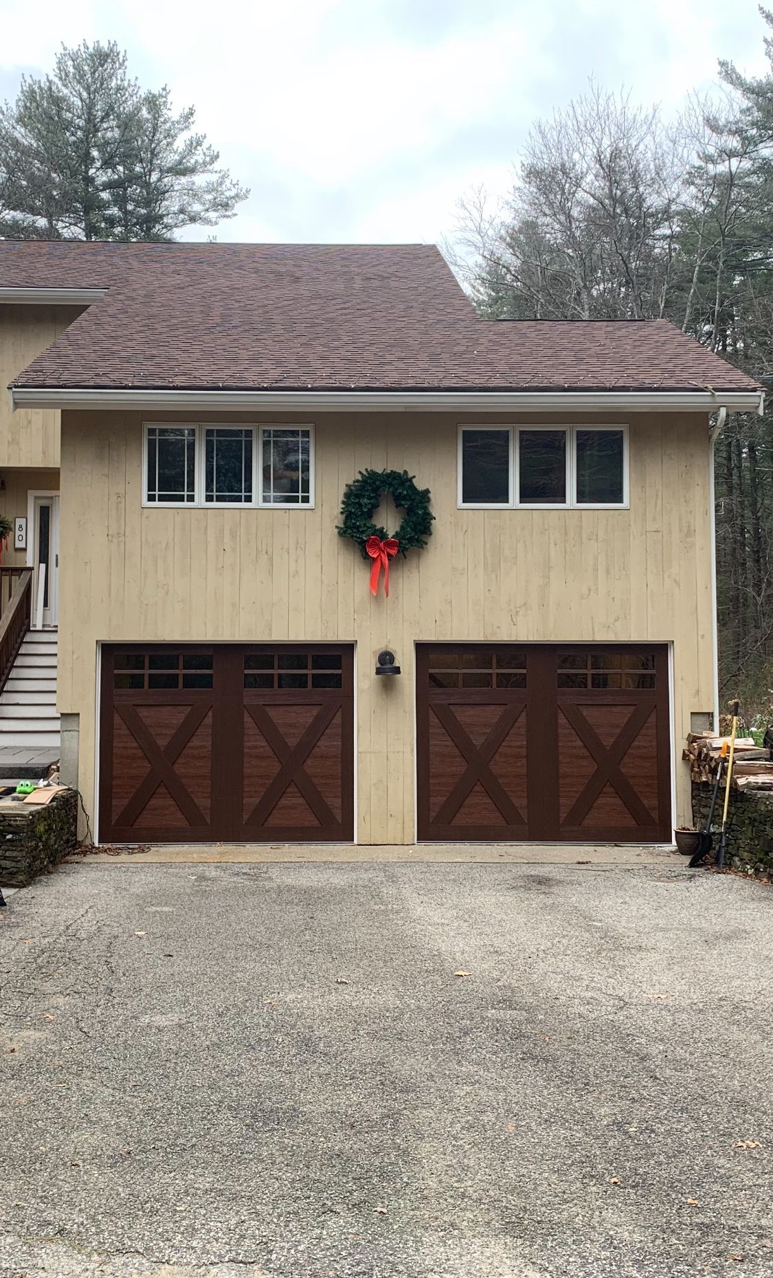 A house with two garage doors and a christmas wreath on the front of it.