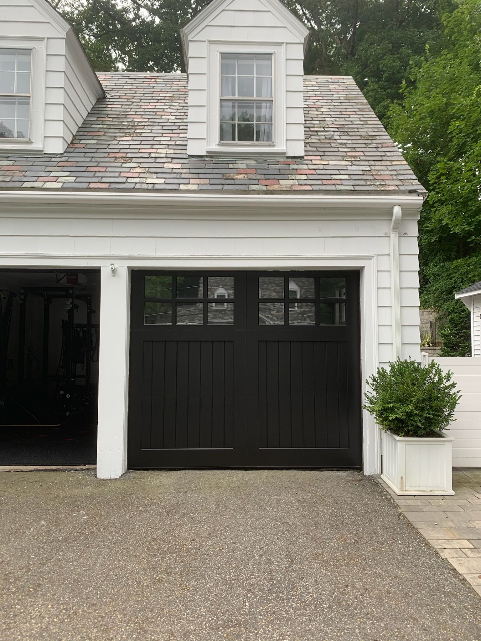 A white house with a black garage door.